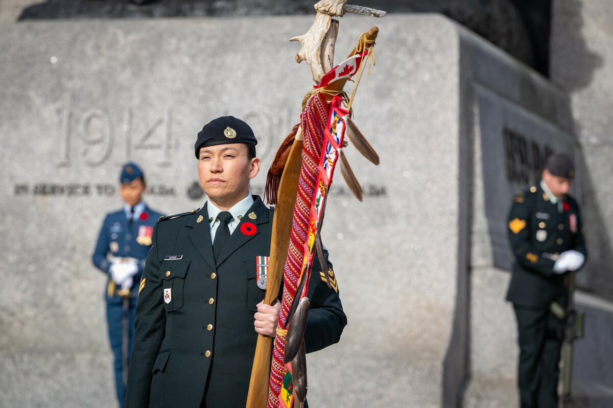 Un militaire autochtone marche devant le Monument commémoratif de guerre du Canada à Ottawa.